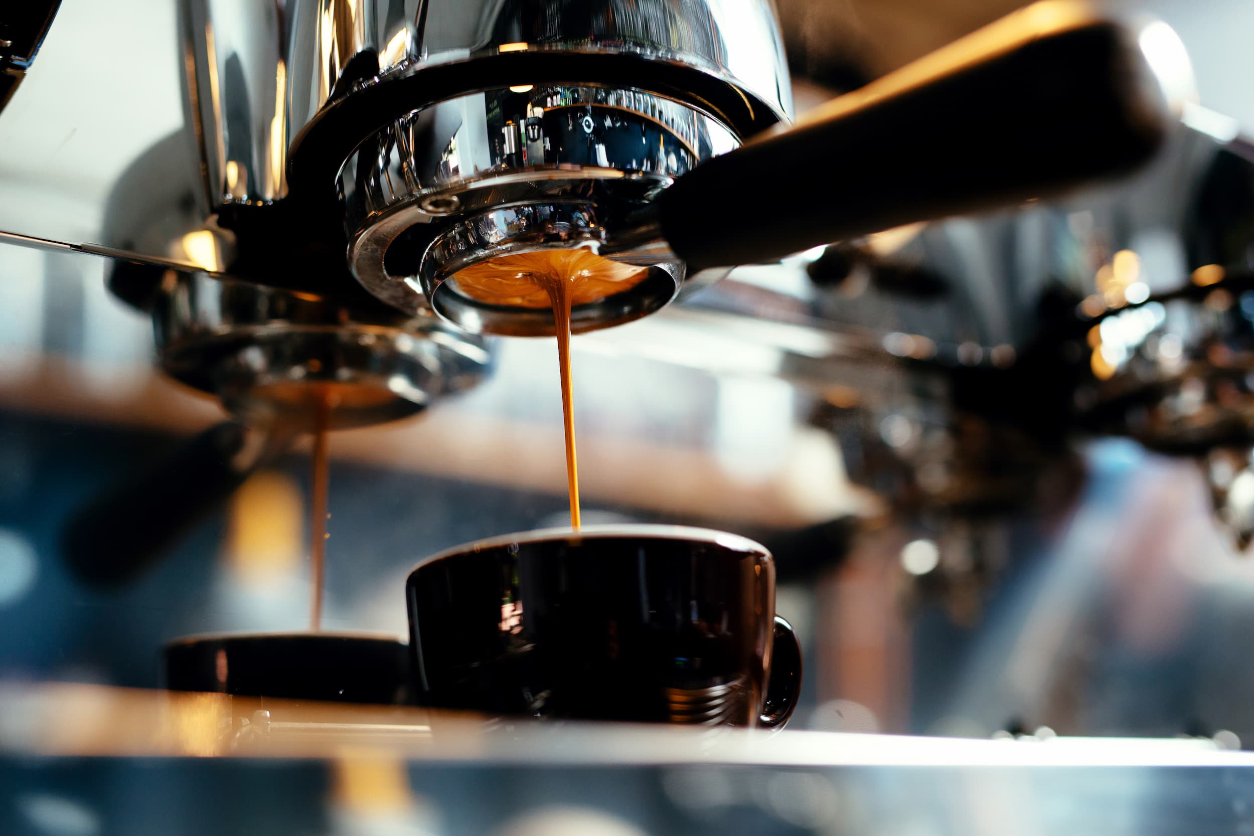 Frischer Espresso aus der Siebträgermaschine Nahaufnahme einer Siebträgermaschine, Espresso läuft in eine Tasse.