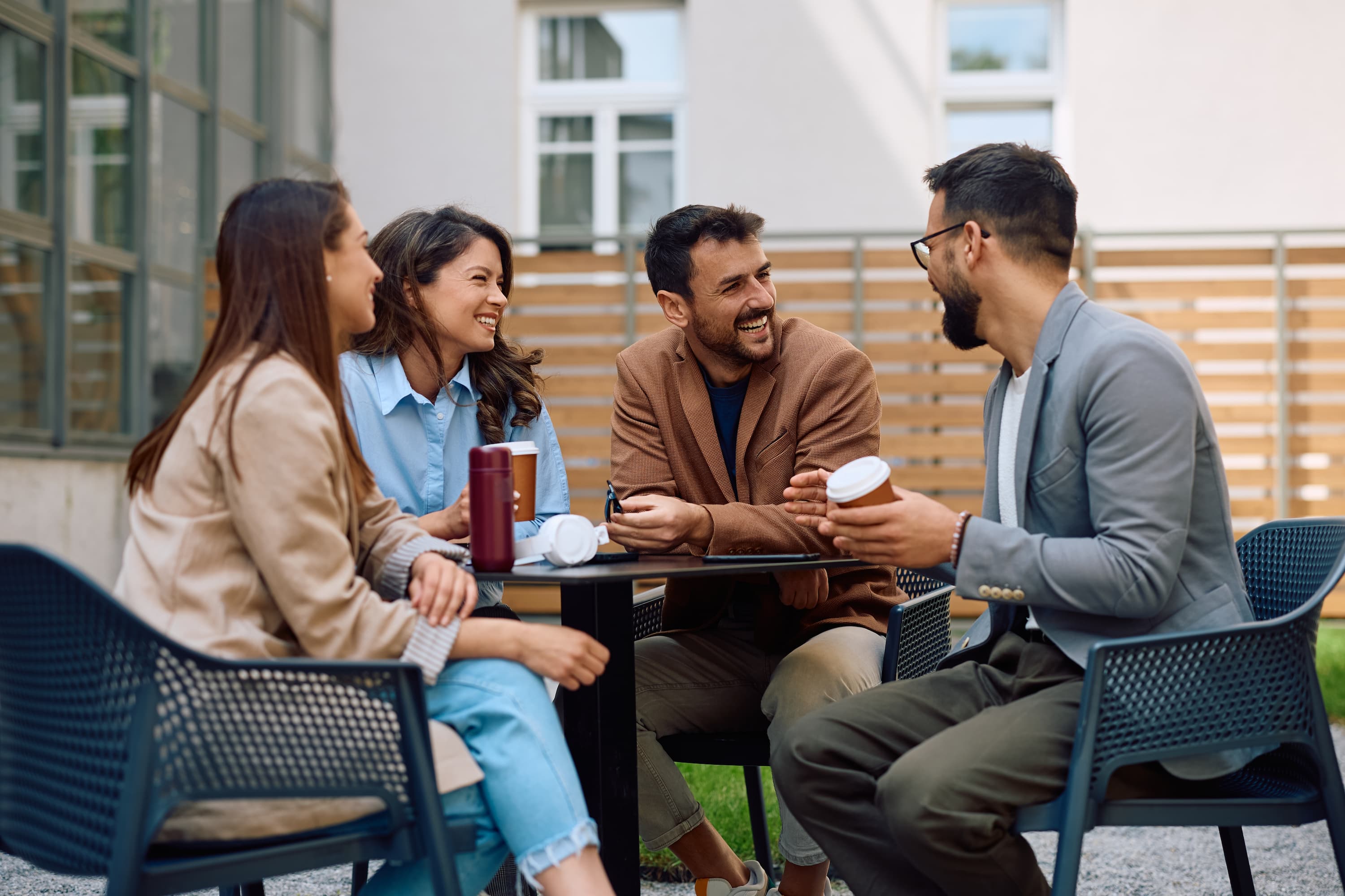Gruppe von Freunden genießt gemeinsam Kaffee im Freien.
