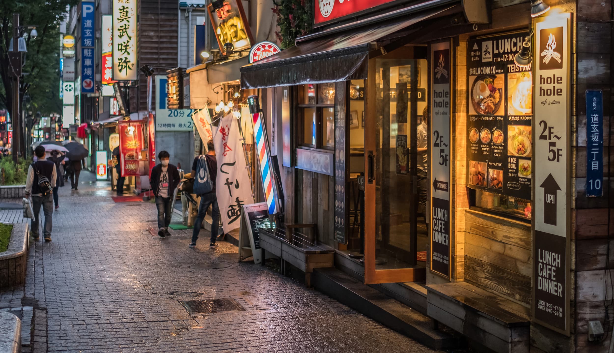 Japanische Straßenszene mit Café Abendliche Straßenszene in Japan mit Restaurants, Cafés und leuchtenden Schildern.