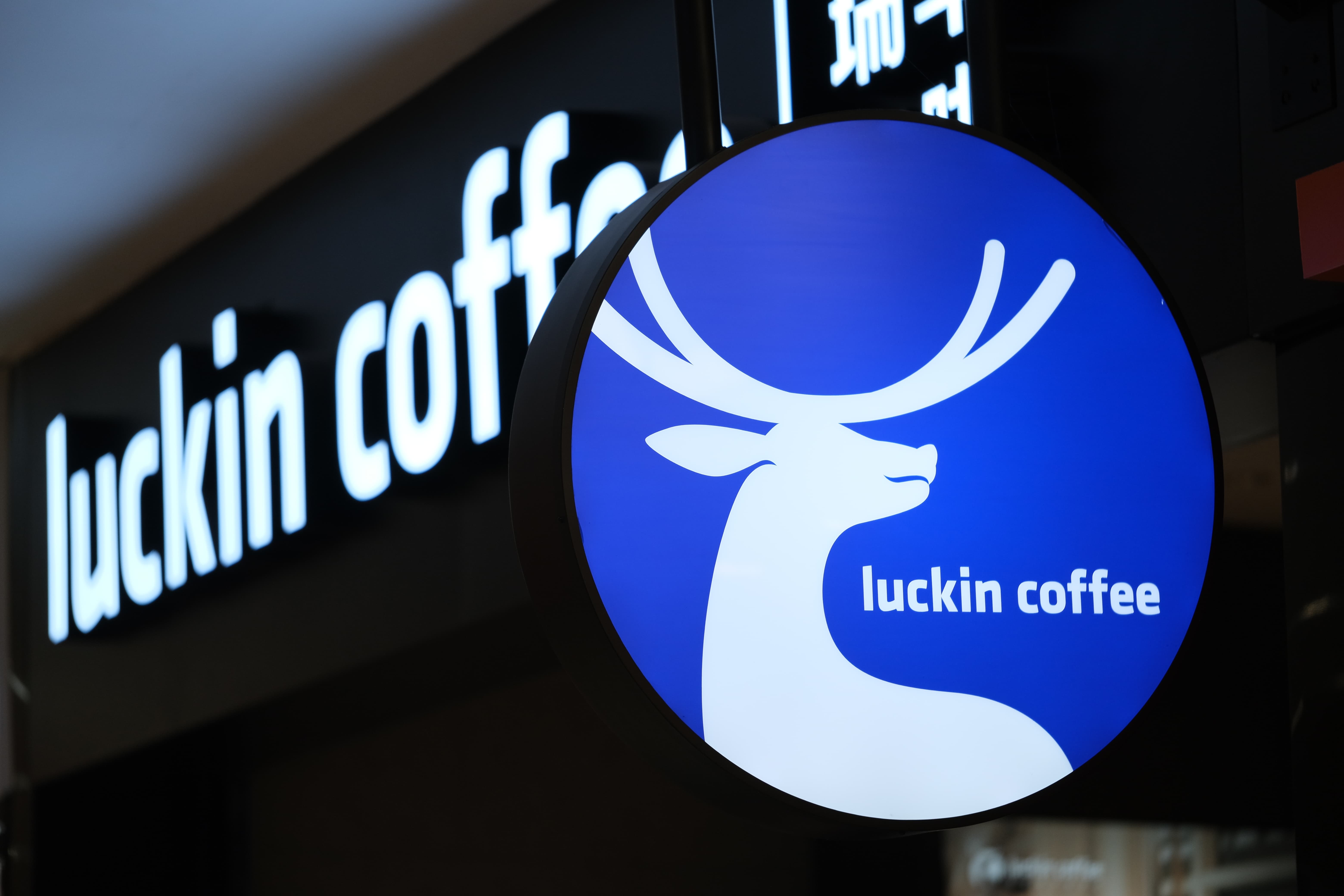 Logo von Luckin Coffee an einer Filiale mit blauem Hirschsymbol.