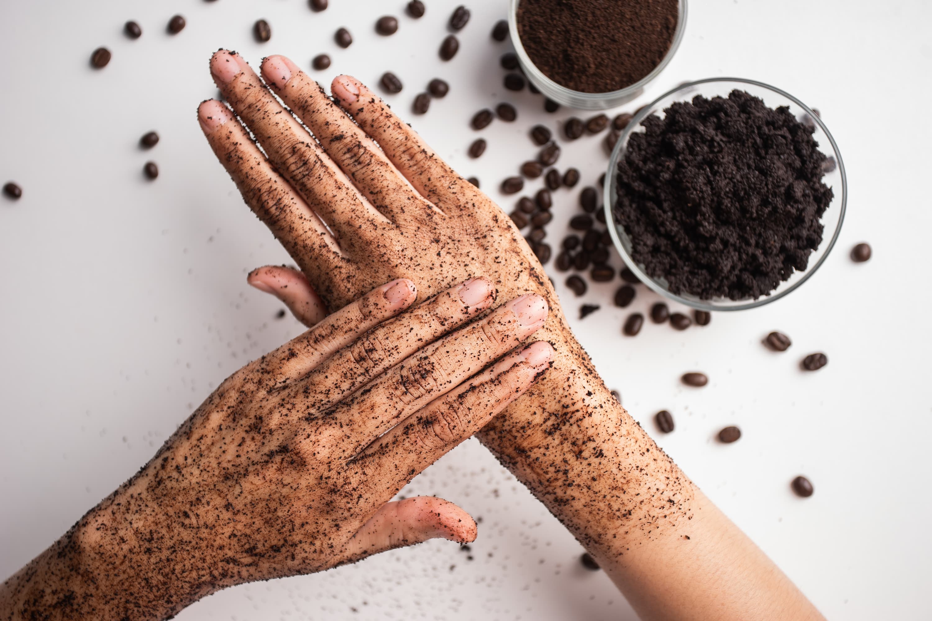 Kaffeepeeling für Hautpflege Hände mit aufgetragenem Kaffeepeeling, natürliche Hautpflege mit Kaffeesatz.