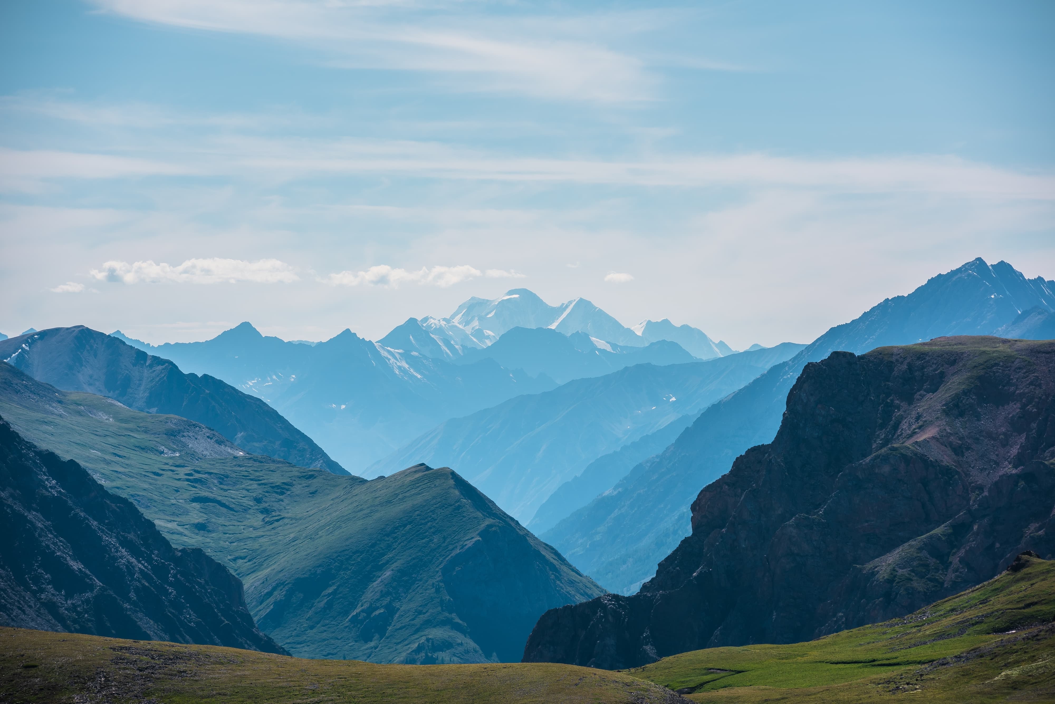 Bergpanorama Majestätisches Bergpanorama mit grünen Tälern und verschneiten Gipfeln in der Ferne.